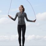 "Person jumping rope outdoors as part of a travel fitness routine with a scenic background"