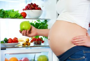 Pregnant lady eating healthy foods to support a healthy pregnancy