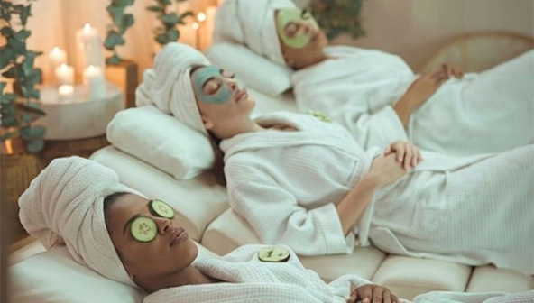 Women relaxing during a spa Pamper Party with cucumber eye masks and candlelight ambiance